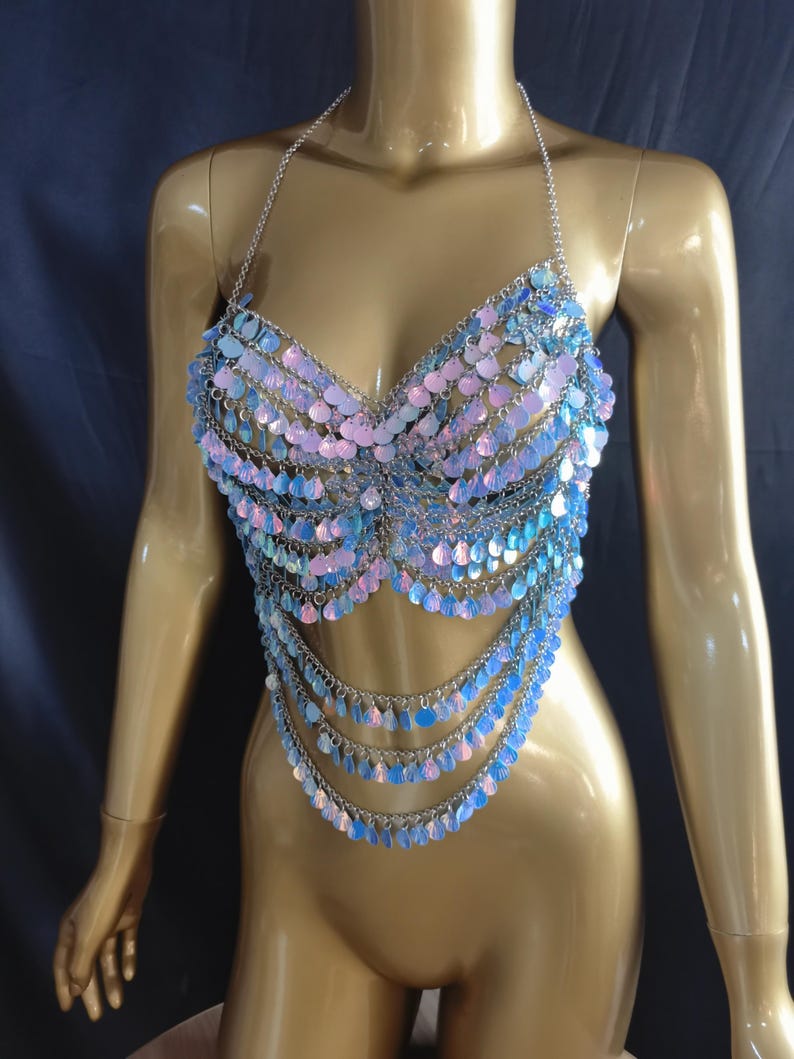 May include: A halter-style body chain top constructed from silver-toned metal links and iridescent, light-reflecting circular sequins. The garment features a structured bodice design with multiple draped chain layers extending downward to the waist.