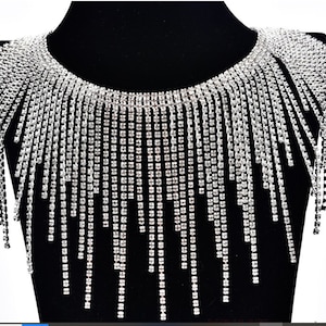 May include: A silver rhinestone choker necklace with a fringe of dangling rhinestones.