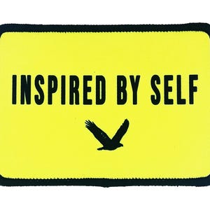 Yellow rectangle patch with bold black text reading “Inspired By Self” and a flying bird graphic, custom printed with iron-on backing.