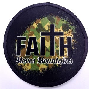 Round iron-on patch with the text "Faith Moves Mountains" printed in black on top of a camouflage background.
