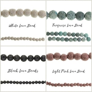 May include: Four rows of lava rock beads in different colors. The top row is white lava beads, the second row is turquoise lava beads, the third row is black lava beads, and the fourth row is light pink lava beads.