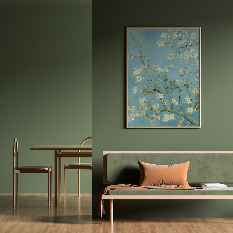 May include: A green living room with a light green sofa, a wooden coffee table, and two chairs. A framed painting of a blooming tree branch hangs on the wall.