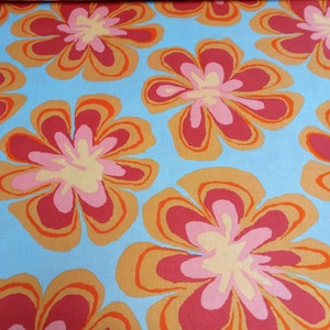 May include: A fabric with a repeating floral pattern. The flowers have a retro design with red, pink, and yellow petals, outlined in orange, set against a light blue background. The fabric is likely used for clothing or home decor.
