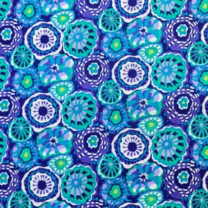 May include: A colourful fabric with a repeating pattern of stylised floral designs. The pattern includes shades of blue, teal, and white against a deep purple background. The design is reminiscent of abstract flowers or aquatic life.