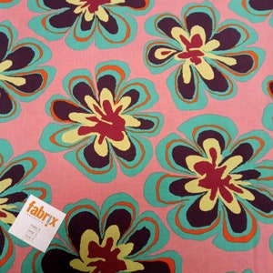 May include: Pink fabric with a repeating floral pattern. The flowers have teal, orange, yellow, and burgundy petals. A white tag with the text "fabrix" and "make it, wear it, love it" is in the lower left corner.