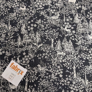 May include: Black fabric with a white woodland print featuring trees, flowers, and animals. The fabric has a textured surface and the print is repeated throughout the fabric. The text "fabrix LANCASTER make it wear it love it" is printed on a white tag.
