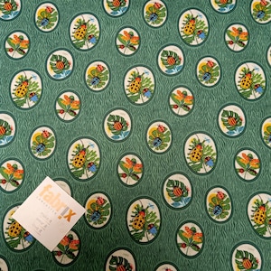 May include: Green fabric with a repeating pattern of white circles containing colourful bugs and leaves. The fabric has a textured, striped background. The text "fabriX" is visible in the bottom left corner of the image.