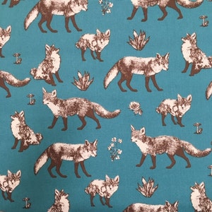 May include: Teal fabric with a repeating pattern of brown foxes. The foxes are in various poses, including walking, sitting, and lying down. The fabric has a subtle texture.