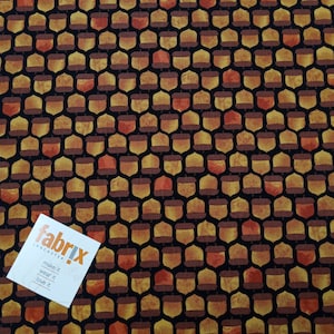 May include: A black fabric with a repeating pattern of brown and orange acorns. The fabric has a textured surface.