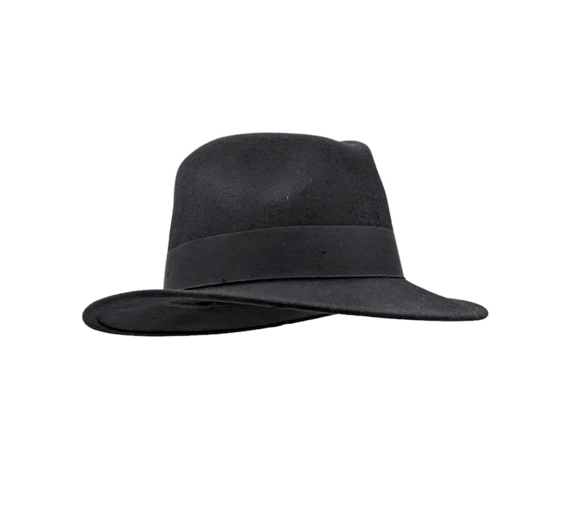 Pu&ograve; includere: Un cappello fedora nero a tinta unita caratterizzato da una corona strutturata e una tesa larga e piatta. Il cappello &egrave; impreziosito da un nastro in gros-grain nero abbinato che circonda la base della corona, offrendo un aspetto uniforme e monocromatico.
