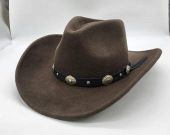 May include: A brown felt cowboy hat with a black leather band and silver concho accents.