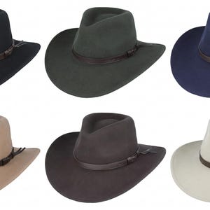 Puede incluir: Una colecci&oacute;n de seis sombreros fedora de fieltro en negro, verde oscuro, azul marino, beige, marr&oacute;n oscuro y crema. Cada sombrero presenta una copa pellizcada, un ala ancha y una banda de cuero marr&oacute;n oscuro con un peque&ntilde;o nudo lateral.
