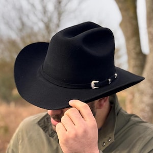 May include: A black felt cowboy hat with a silver buckle and a wide brim.