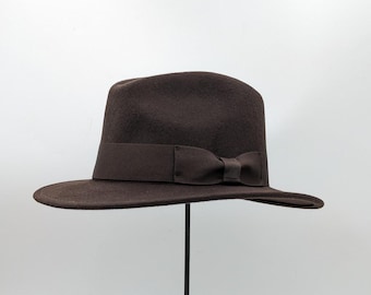 May include: A brown felt fedora hat with a brown grosgrain ribbon and a bow.
