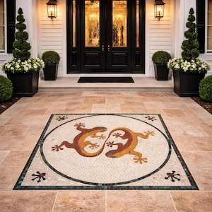 May include: Exterior view of a home's entrance featuring a mosaic tile design. The mosaic depicts two lizards in shades of brown and gold, surrounded by a circular border. The entrance includes black double doors, lanterns, and potted plants.