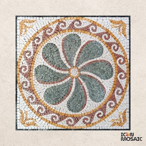 May include: Square mosaic tile with a floral design. The center features a flower shape in shades of green, surrounded by a ring of red and gold. The border is white with decorative corner accents. The tile is from Icon Mosaic.