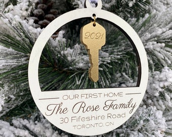 May include: White wooden Christmas ornament with a gold key and the text "Our First Home - The Rose Family - 30 Fifeshire Road - TORONTO, ON - 2021"
