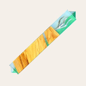 Könnte beinhalten: Eine Holz-Mezuzah mit einer grünen und blauen Harzeinlage, die ein silbernes Menora-Design zeigt.