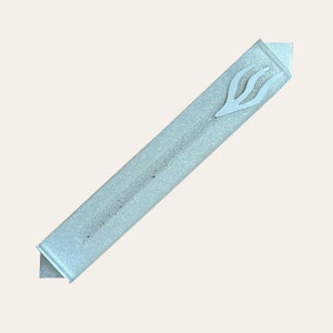 Könnte beinhalten: Eine hellblaue Mezuzah mit einem weißen Glitzerfinish und einem silberfarbenen Flammenmotiv.