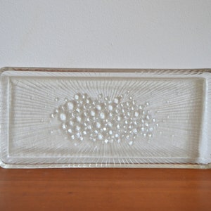 May include: A clear glass serving tray with a raised, textured design of small circles in the center. The tray has a rectangular shape with slightly rounded corners.
