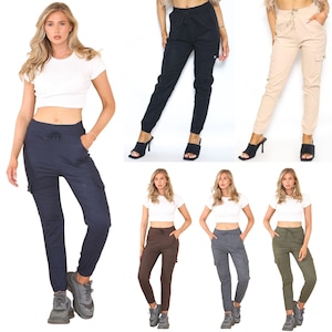 May include: Five models wearing different coloured cargo trousers. The trousers have a drawstring waist and multiple pockets. The trousers are available in black, khaki, brown, grey, and green.