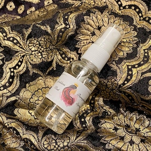 May include: A clear glass bottle with a white spray nozzle and a label that reads "Goddess Mist" and "Perfume Spray".