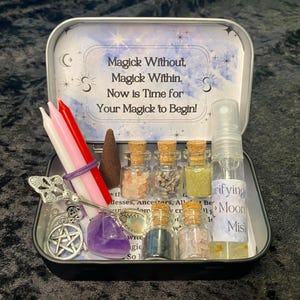 May include: A silver tin with a blue and white starry background. The tin contains a variety of items for a magical ritual, including candles, incense, crystals, and a bottle of mist. The text on the tin reads "Magick Without, Magick Within. Now is Time for Your Magick to Begin!"