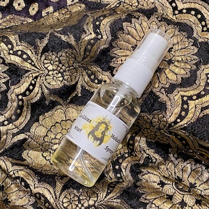 May include: A clear glass bottle with a white spray top. The bottle is labelled "Goddess Mist Hekate Spray".