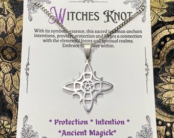 May include: A silver-toned pendant necklace featuring a stylized starburst design with a pentagram center. The pendant hangs from a delicate chain. The card behind the necklace reads "Witches Knot" and includes text about protection and intention.