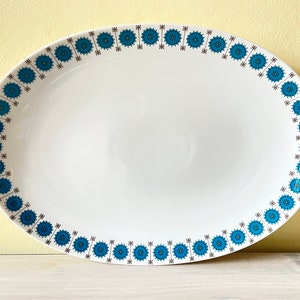 Op de afbeelding: Witte ovale serveerschaal met een blauw en bruin bloemenpatroon rond de rand.