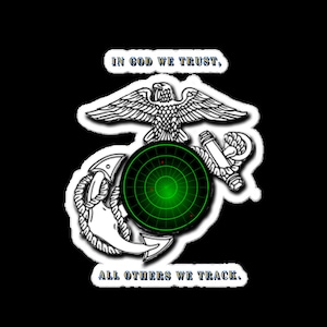 May include: A black and white image of the US Marine Corps emblem with a green radar screen in the centre. The text "IN GOD WE TRUST, ALL OTHERS WE TRACK." is below the emblem.