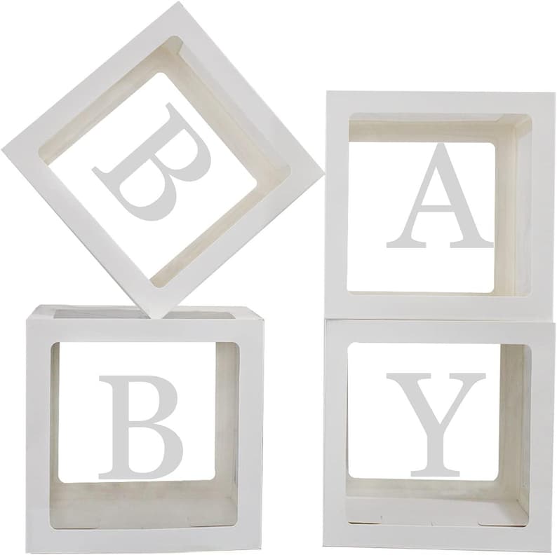 May include: Four white square boxes spelling out the word "BABY". Each box has a letter cut out in the center. The boxes are arranged to spell the word "BABY".