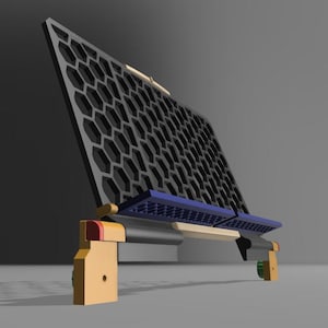 Puede incluir: Estructura geométrica con un panel negro en forma de panal de abeja sostenido por un marco marrón claro con detalles azules y rojos. El diseño sugiere un objeto moderno, posiblemente funcional.