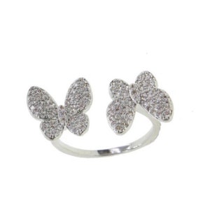 May include: A silver ring with two butterfly designs, each adorned with sparkling clear stones.