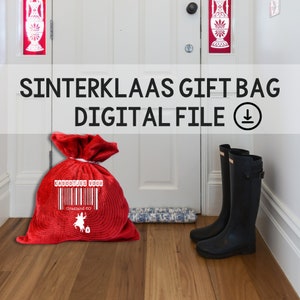 May include: Red felt gift bag with white text that says "Kadootjes voor Grasland 80" and a barcode. The bag is sitting on a wooden floor in front of a white door. There are two black rain boots on the floor.
