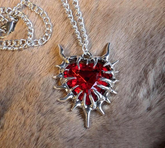 Collar gótico con corazón puntiagudo y piedra roja.