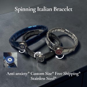 Può includere: Tre bracciali a maglie modulari in acciaio inossidabile. Uno è blu scuro, uno è argento e uno è grigio scuro. Ognuno presenta un ciondolo circolare rotante con disegni che includono un occhio blu, una spirale bianca e una spirale rossa.