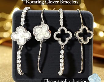 May include: Four silver-toned clover bracelets with sparkling accents are displayed on a black stand. The bracelets have a rotating clover design, with one featuring a white center. The text "Rotating Clover Bracelets" and "Elegant soft vibration" are visible.