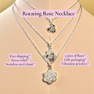 May include: A silver necklace featuring three rose pendants of different sizes. The smallest pendant is at the top, with a medium and large one below. The necklace is shown on a mannequin.