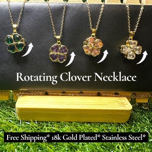 May include: Four gold-colored necklaces with rotating clover pendants in green, purple, peach, and clear crystal. The necklaces hang against a black background with the text "Rotating Clover Necklace".