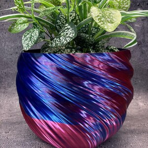 Op de afbeelding: Een set van drie keramische nestkommen in blauwe, groene en witte tinten. De kommen hebben een gespikkelde glazuur en een eenvoudig, modern ontwerp. De grootste kom heeft een diameter van ongeveer 20 cm.
