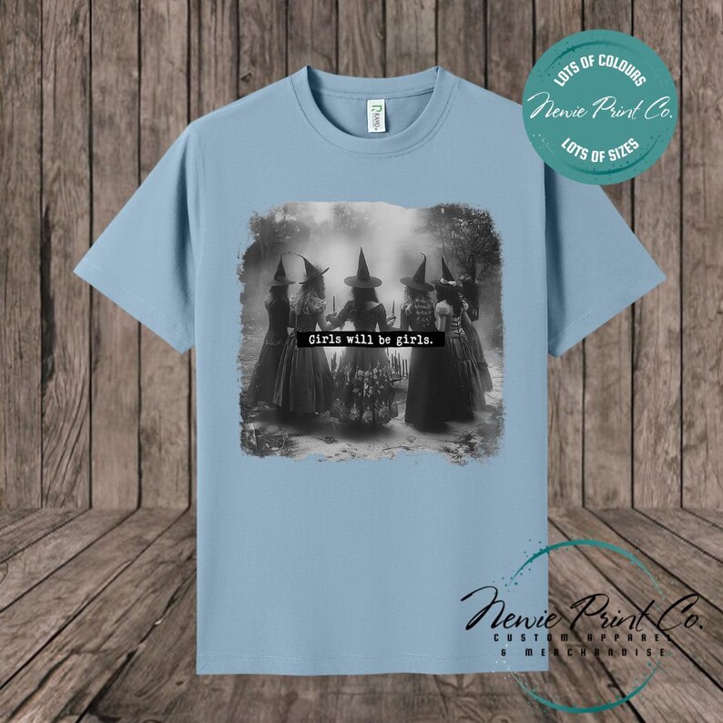 Witches in the forest design on custom t-shirt with the slogan “Girls Will Be Girls”. Feminist and empowering print on 100% cotton tee, perfect for girls and women, printed using high-quality DTF/DTG technology.