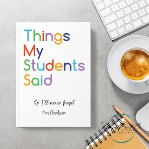 May include: A white notebook with the title "Things My Students Said" in rainbow-colored letters. The text "So I'll never forget Mrs Clarkson" is below. The notebook is on a desk with a keyboard, coffee, and a notepad.