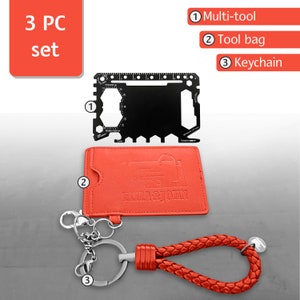 May include: A 3-piece set of a black multi-tool, a red leather tool bag, and a red braided keychain. The multi-tool has a ruler, bottle opener, and other tools. The tool bag has the text "Pizza & John" on it. The keychain has a silver ring and a braided cord.