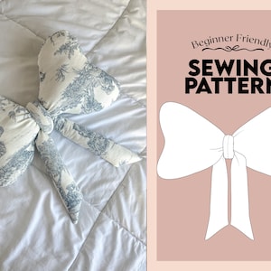 May include: A bow-shaped cushion with a blue and white toile pattern, lying on a white duvet. Beside it is a pink background with a white bow illustration and the text "Beginner Friendly SEWING PATTERN."