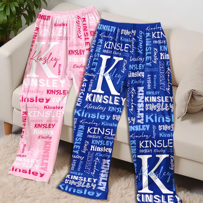May include: Pink and blue pajama pants with the name "Kinsley" printed repeatedly in a script font. The letter "K" is prominently displayed on the front of each pair of pants. The pajamas are made of a soft material.