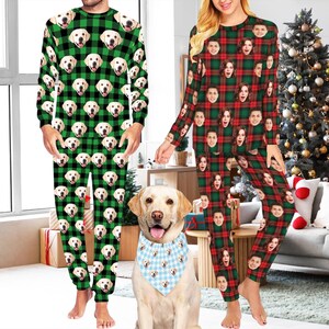 May include: Matching green and black plaid pajamas with dog faces printed all over. A person is wearing the pajamas. A dog is wearing a blue and white bandana with dog faces. A person is wearing red and green plaid pajamas with faces printed all over.