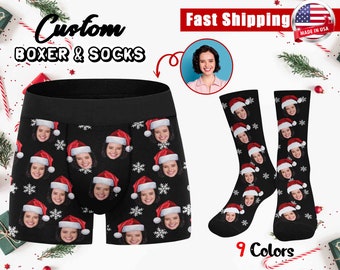 May include: Custom boxer shorts and socks with a Christmas theme. The fabric features a repeating pattern of a person's face wearing a Santa hat and snowflakes on a black background.  "Custom Boxer & Socks" and "Fast Shipping" are written in the image.  "Made in USA" is also written in the image.