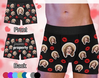May include: Black boxer shorts with a red lip print and a repeated image of a woman's face. The text "Jessica's property" is printed on the back of the shorts.