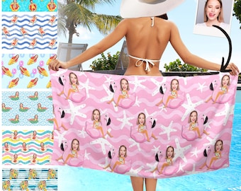 May include: A pink beach towel featuring a repeating pattern of a person in a flamingo floatie, white starfish, and wavy lines. The towel is held by a person wearing a white bikini and a large sun hat. Additional patterns are shown.